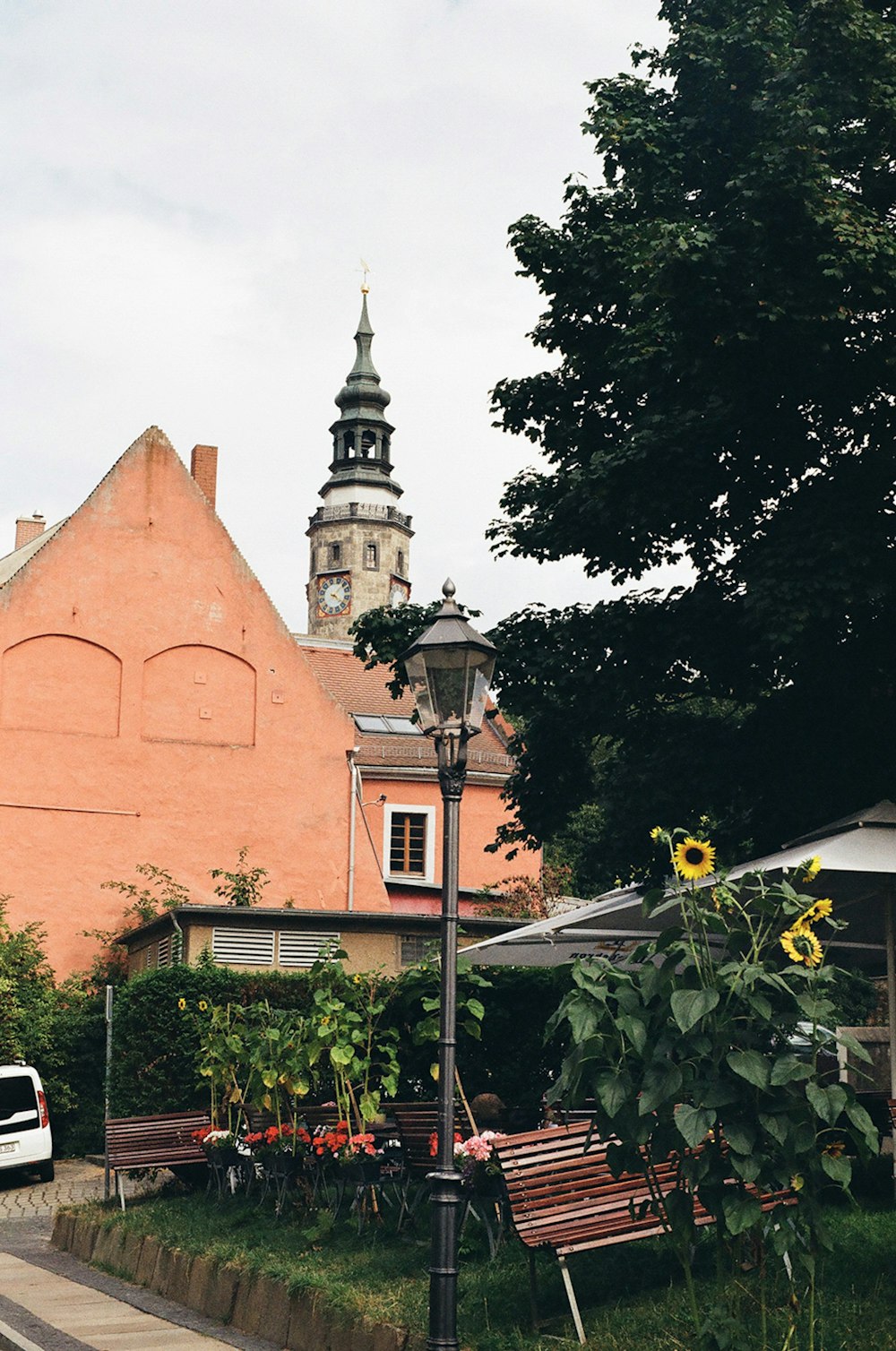 a street light sitting next to a building with a clock tower in the background