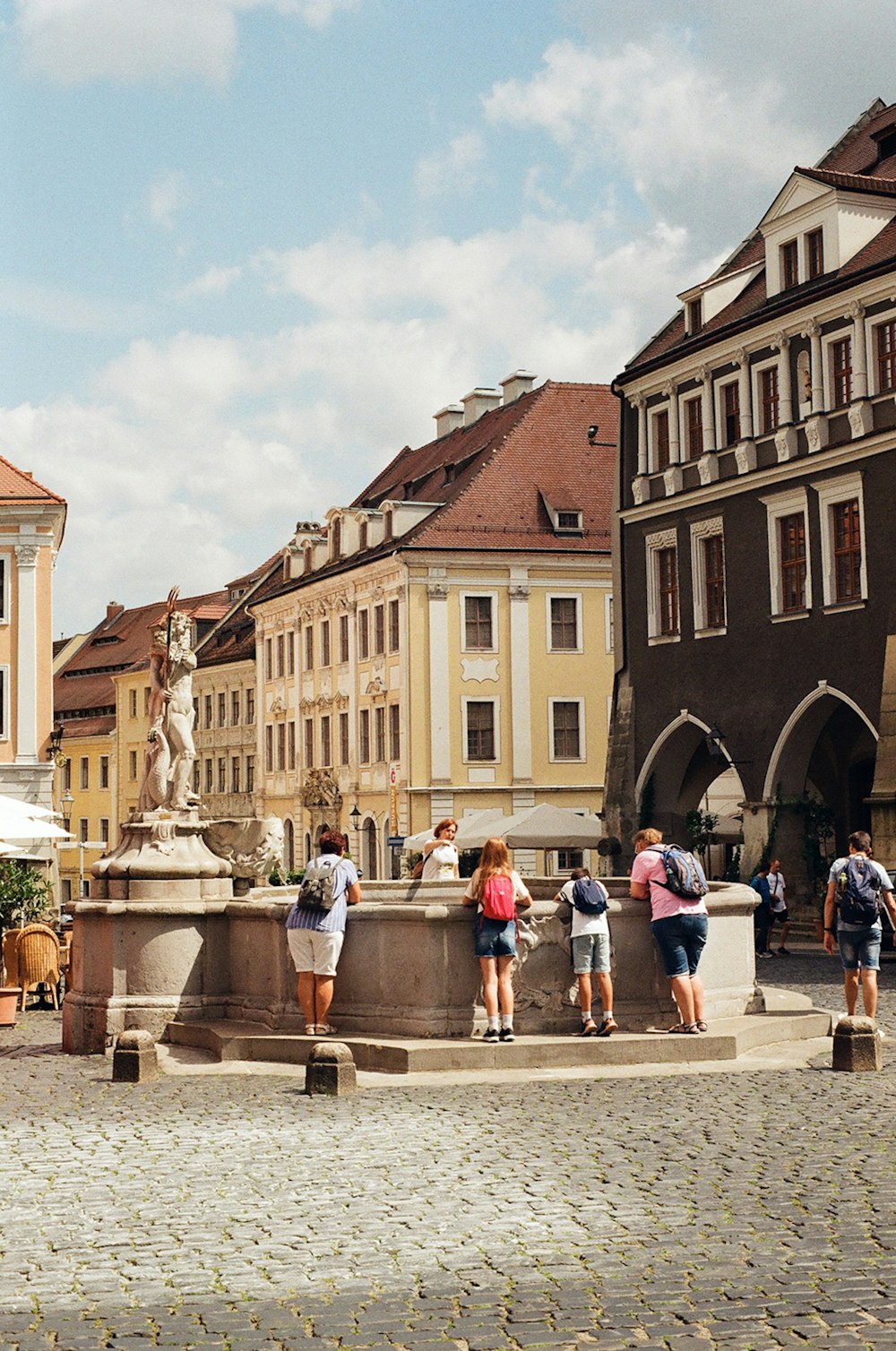 a group of people standing around a fountain