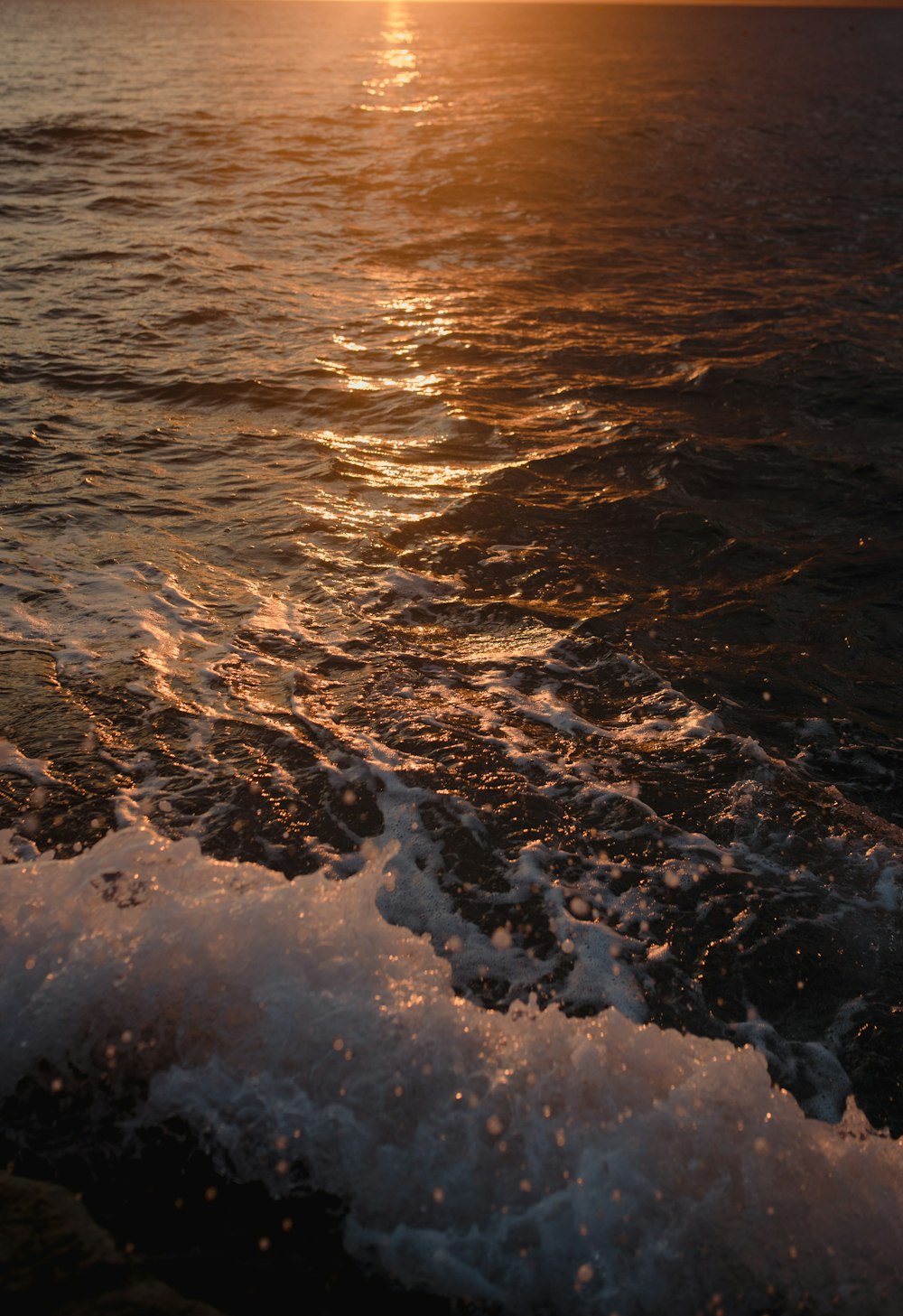 the sun is setting over the ocean waves