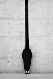 a person standing in front of a concrete wall