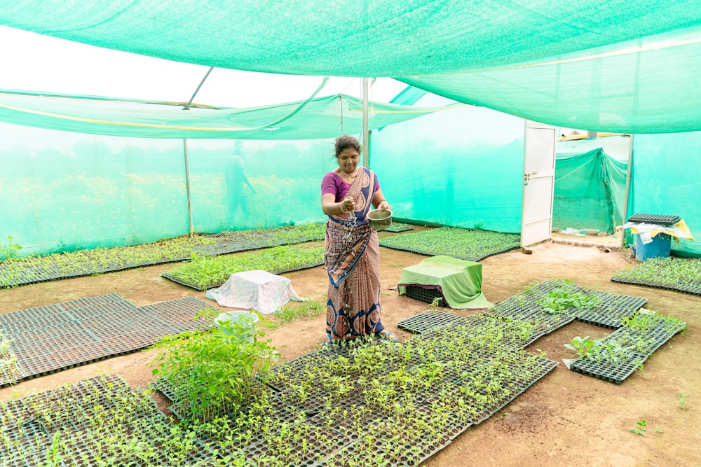 a woman standing in a green room with lots of plants