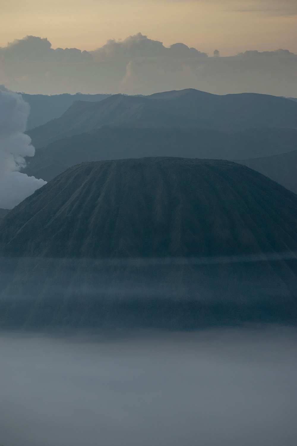 an airplane flying over a mountain covered in fog