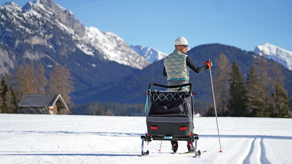 a man on skis is pulling a stroller