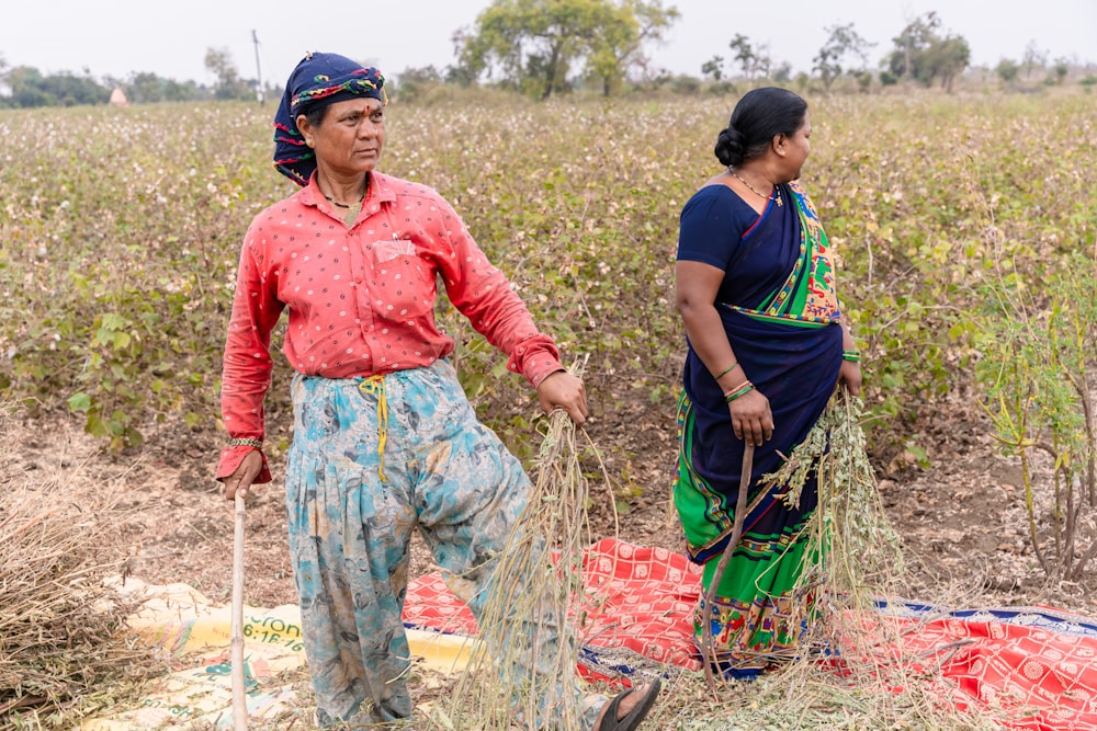 a couple of women standing next to each other in a field