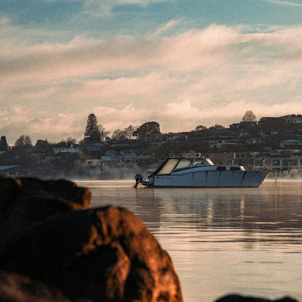 a white boat floating on top of a body of water