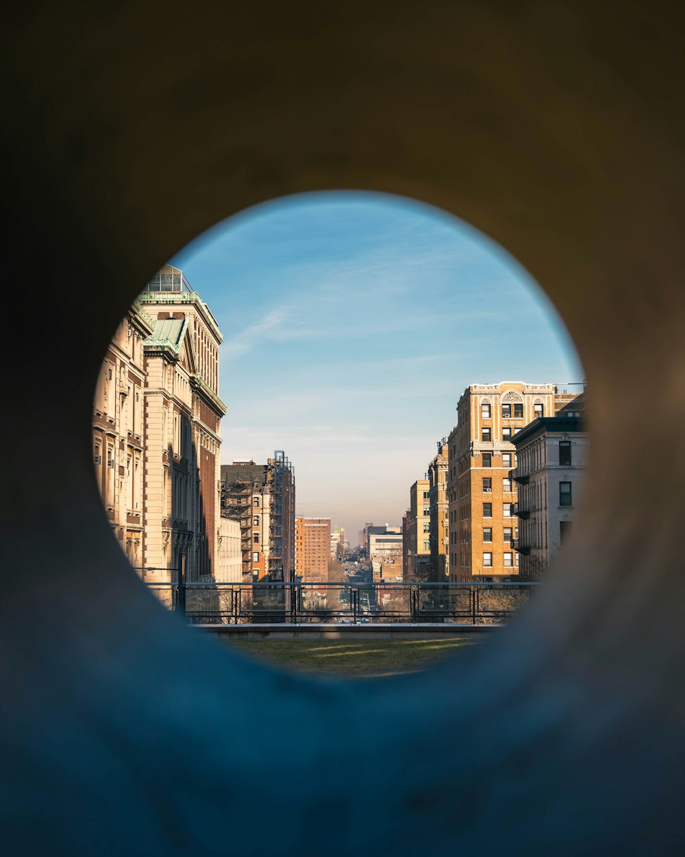 a view of a city through a hole in a wall