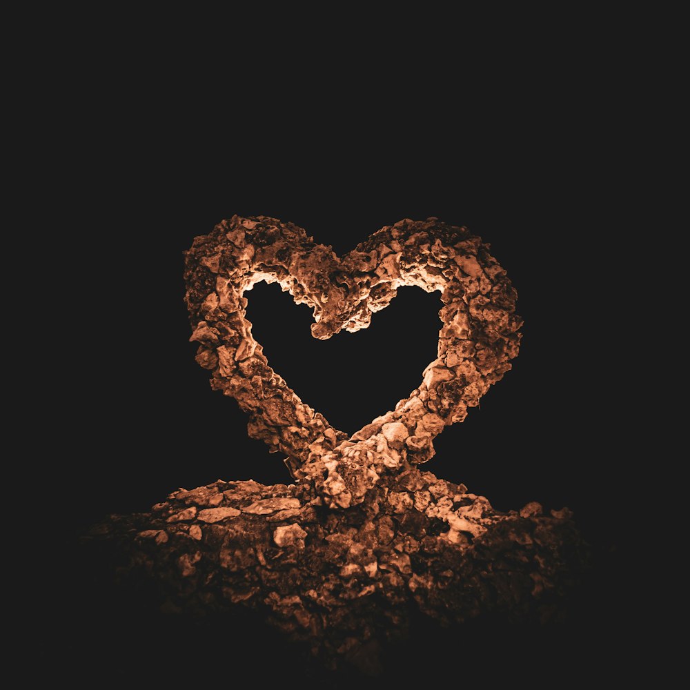 a heart made out of rocks on a black background