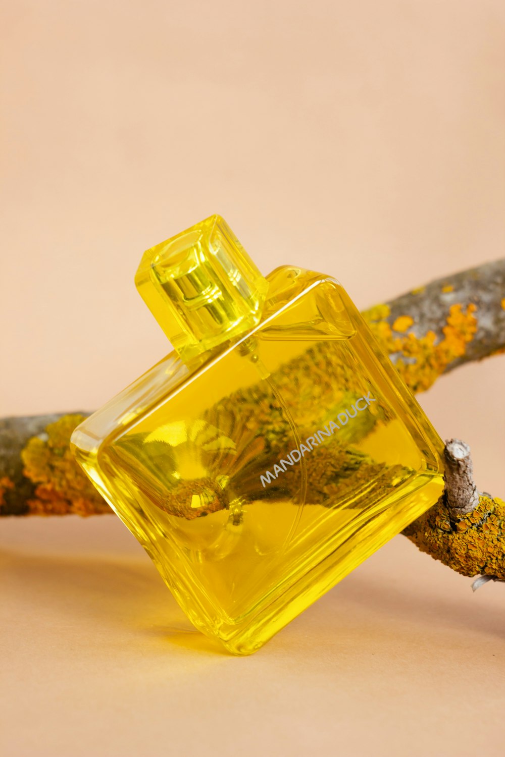 a bottle of perfume sitting on top of a branch