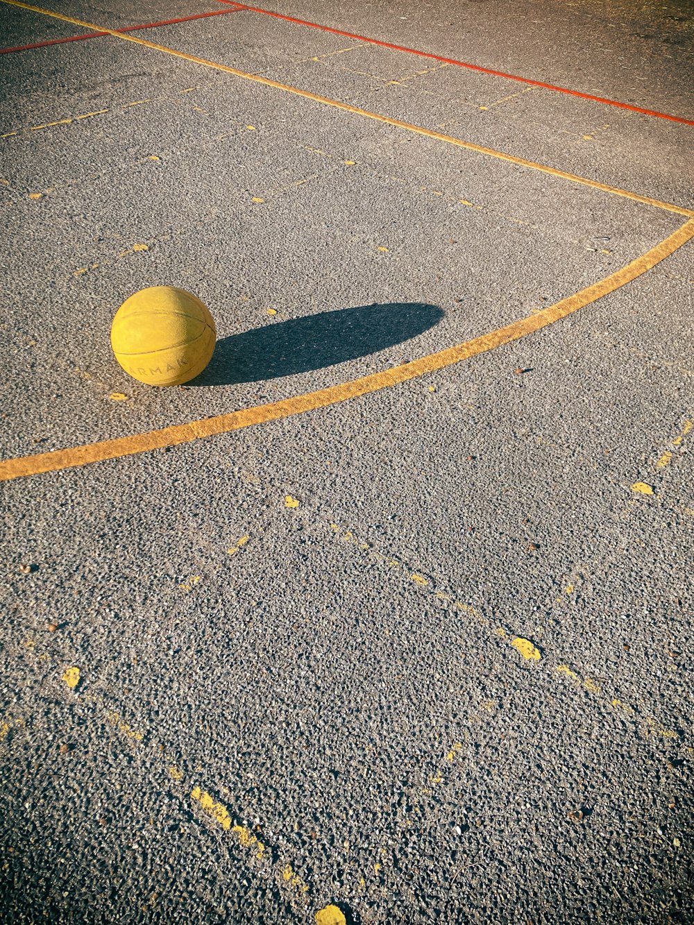 a yellow ball sitting on top of a basketball court