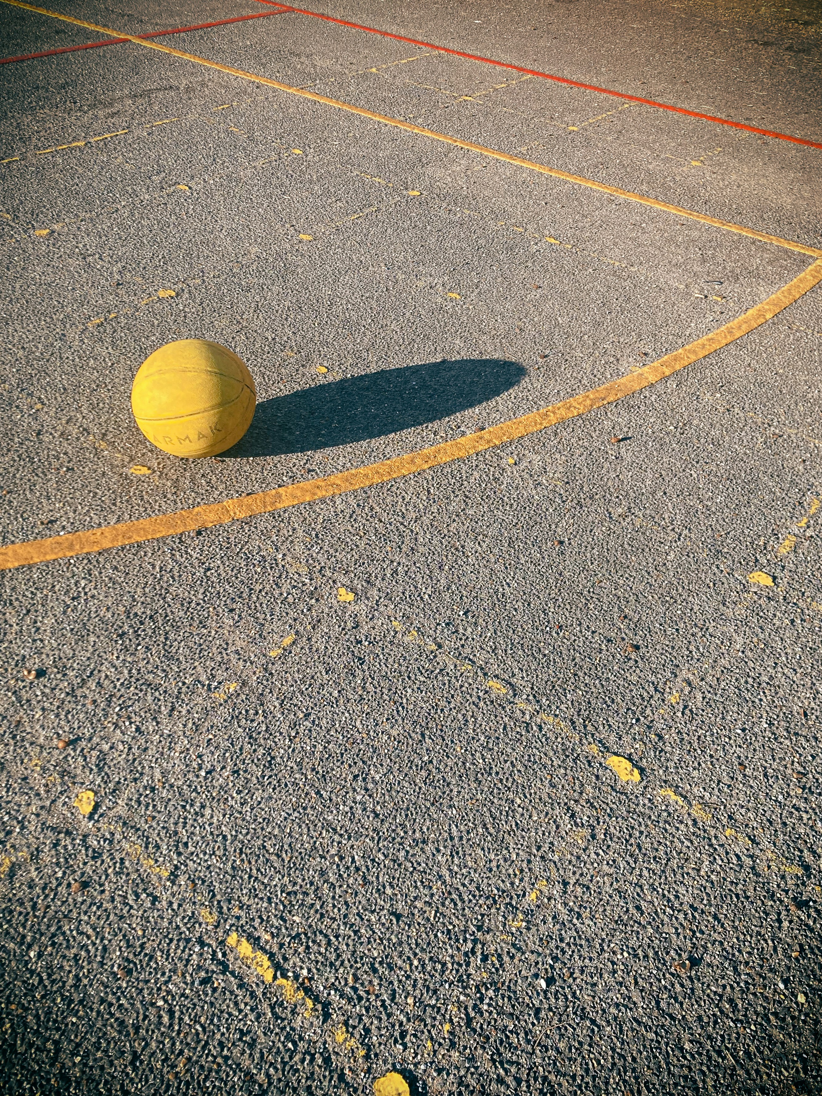 a yellow ball sitting on top of a basketball court