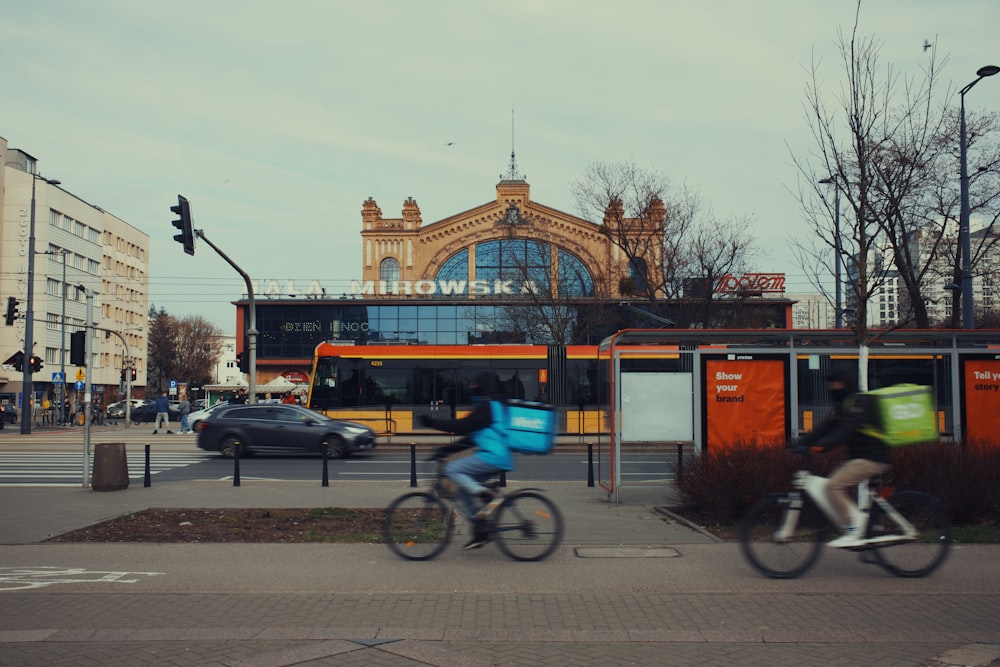 a couple of people riding bikes down a street