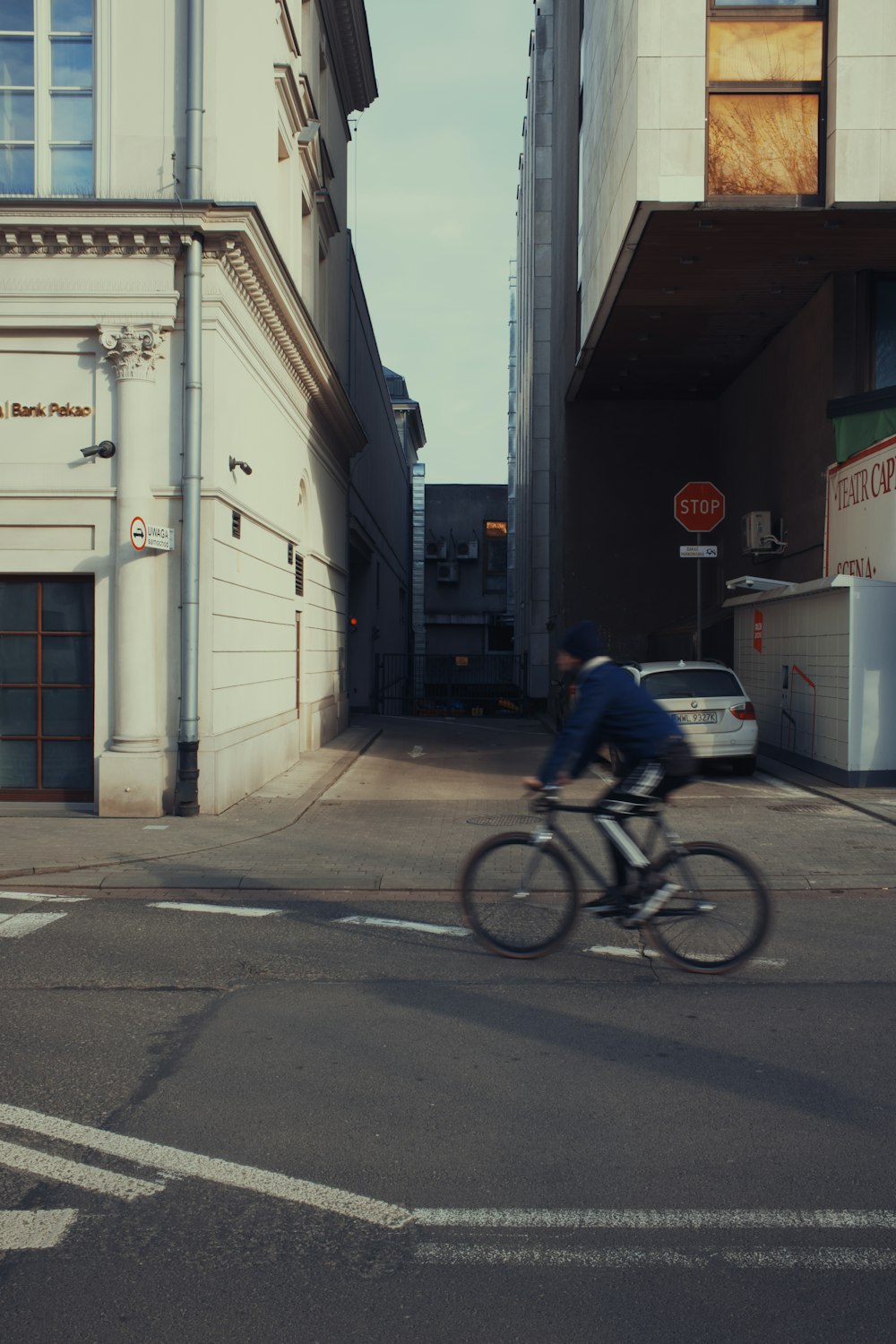 a man riding a bike down a street next to tall buildings