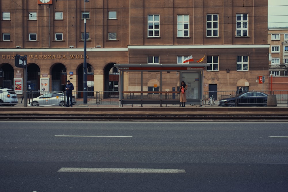 a train station with cars parked on the side of the road