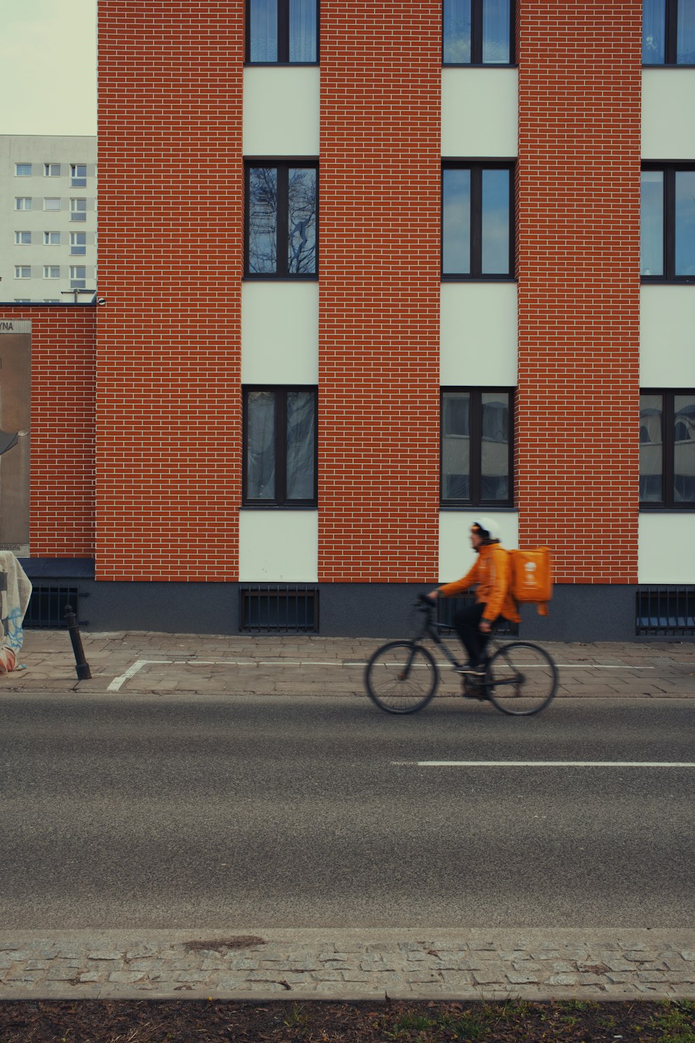 a man riding a bike down a street next to a tall building