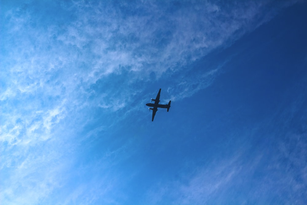 Un avión vuela alto en el cielo