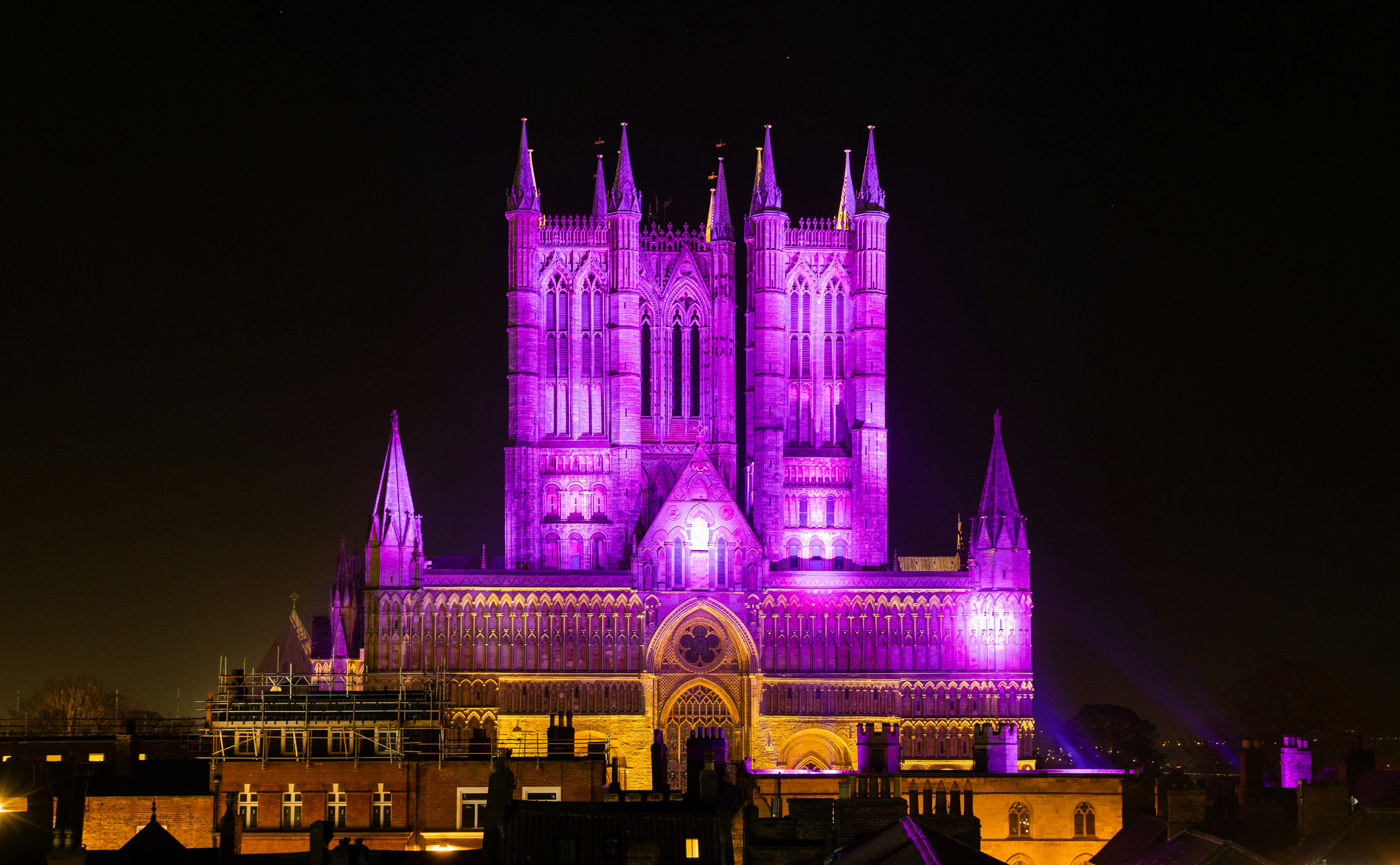 a large cathedral lit up in purple at night