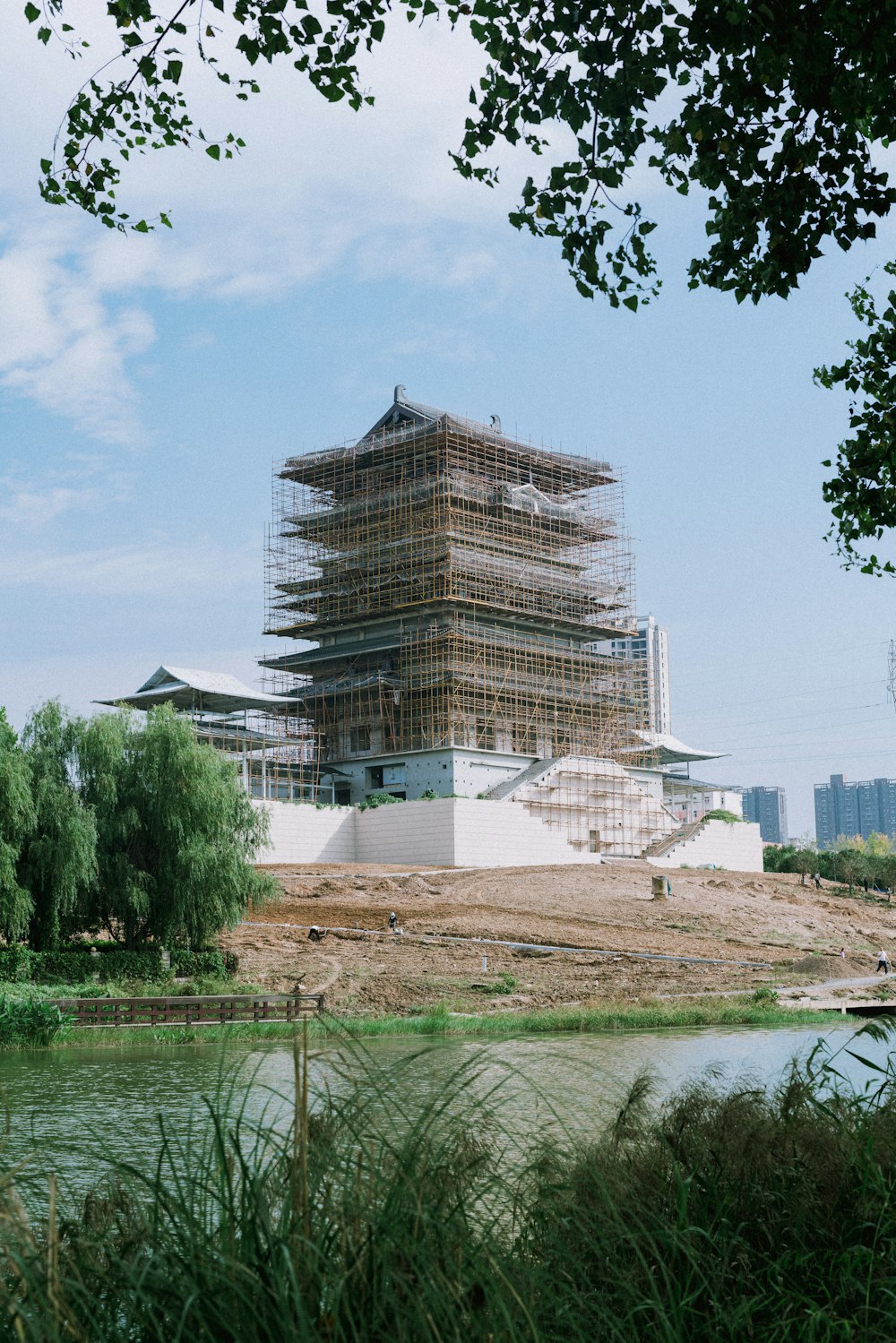 a large building under construction next to a body of water