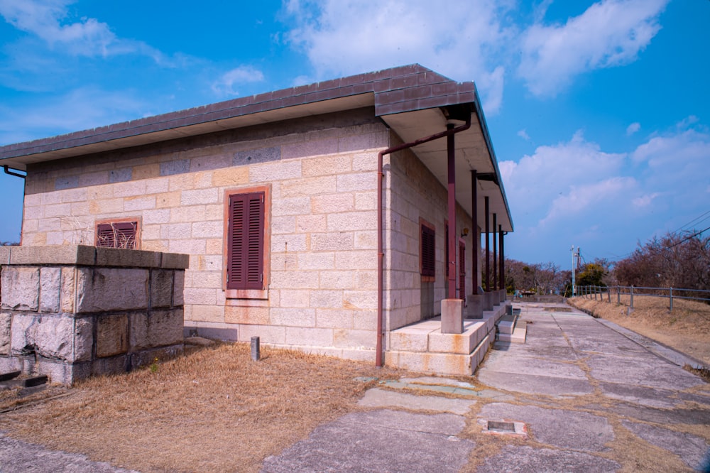 Un pequeño edificio de ladrillo con una puerta y una ventana rojas