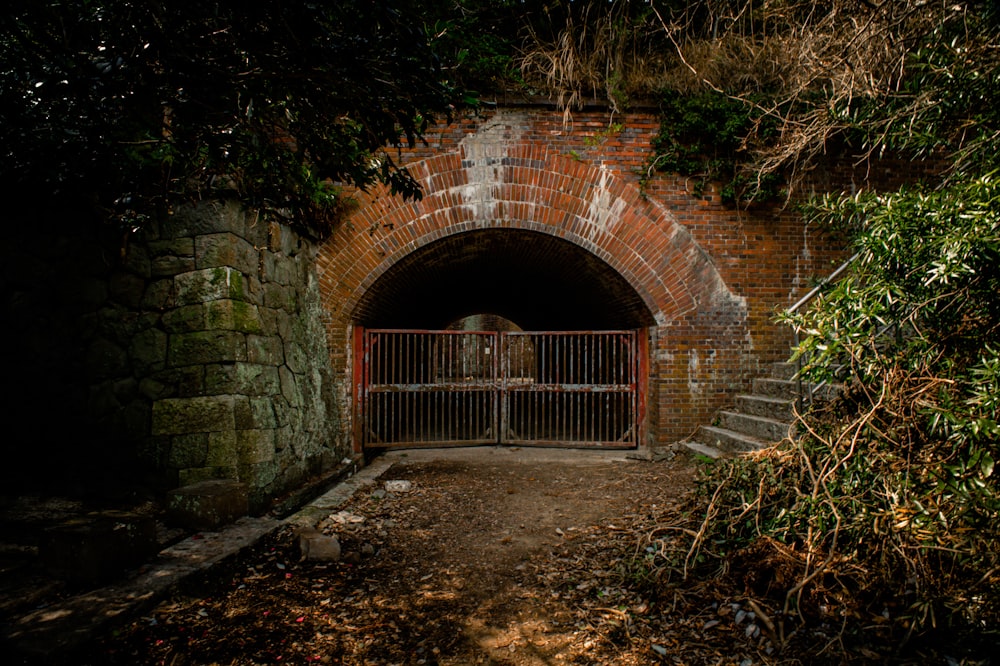 a brick tunnel with a gate and a gated entrance