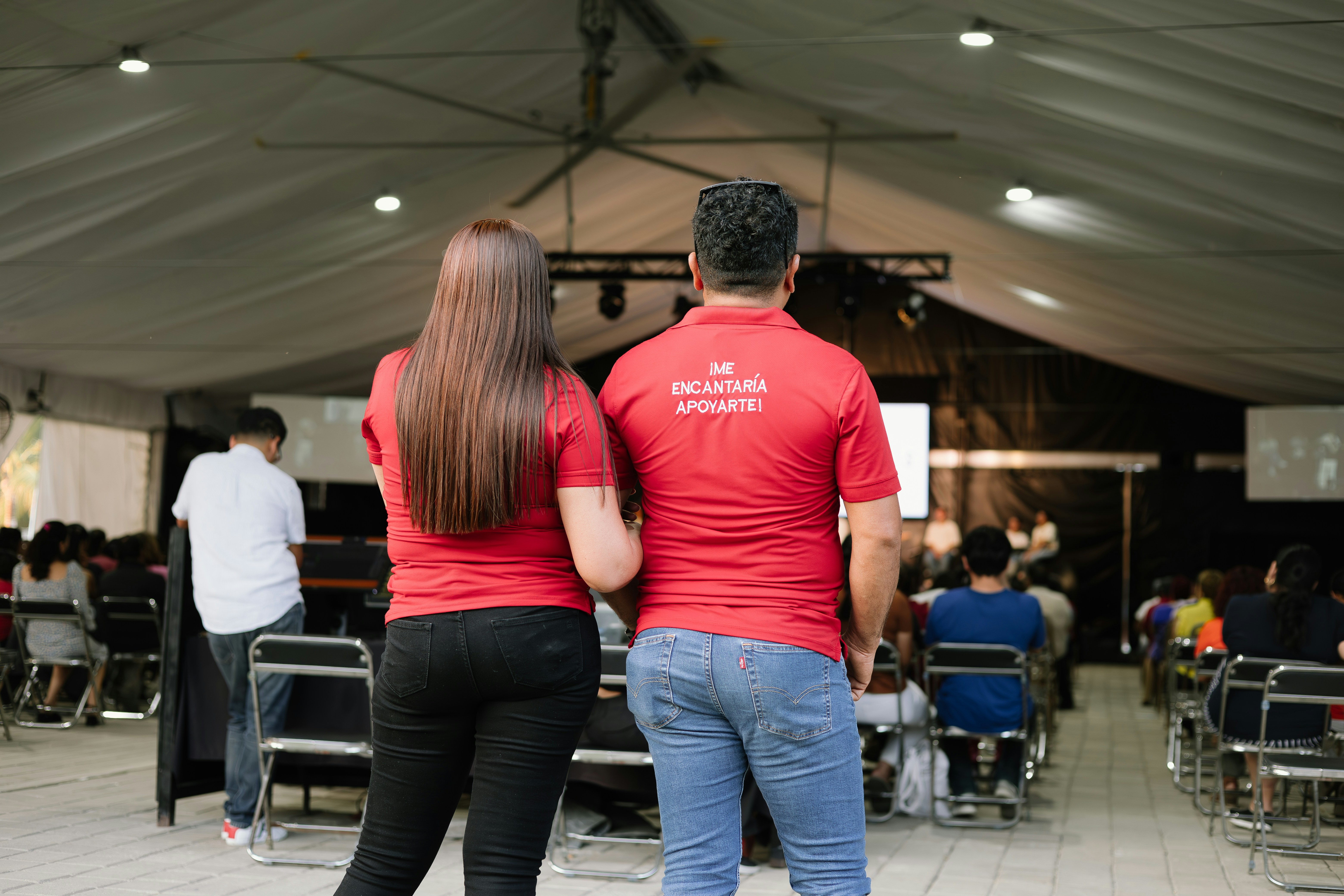a man and a woman standing in front of a crowd