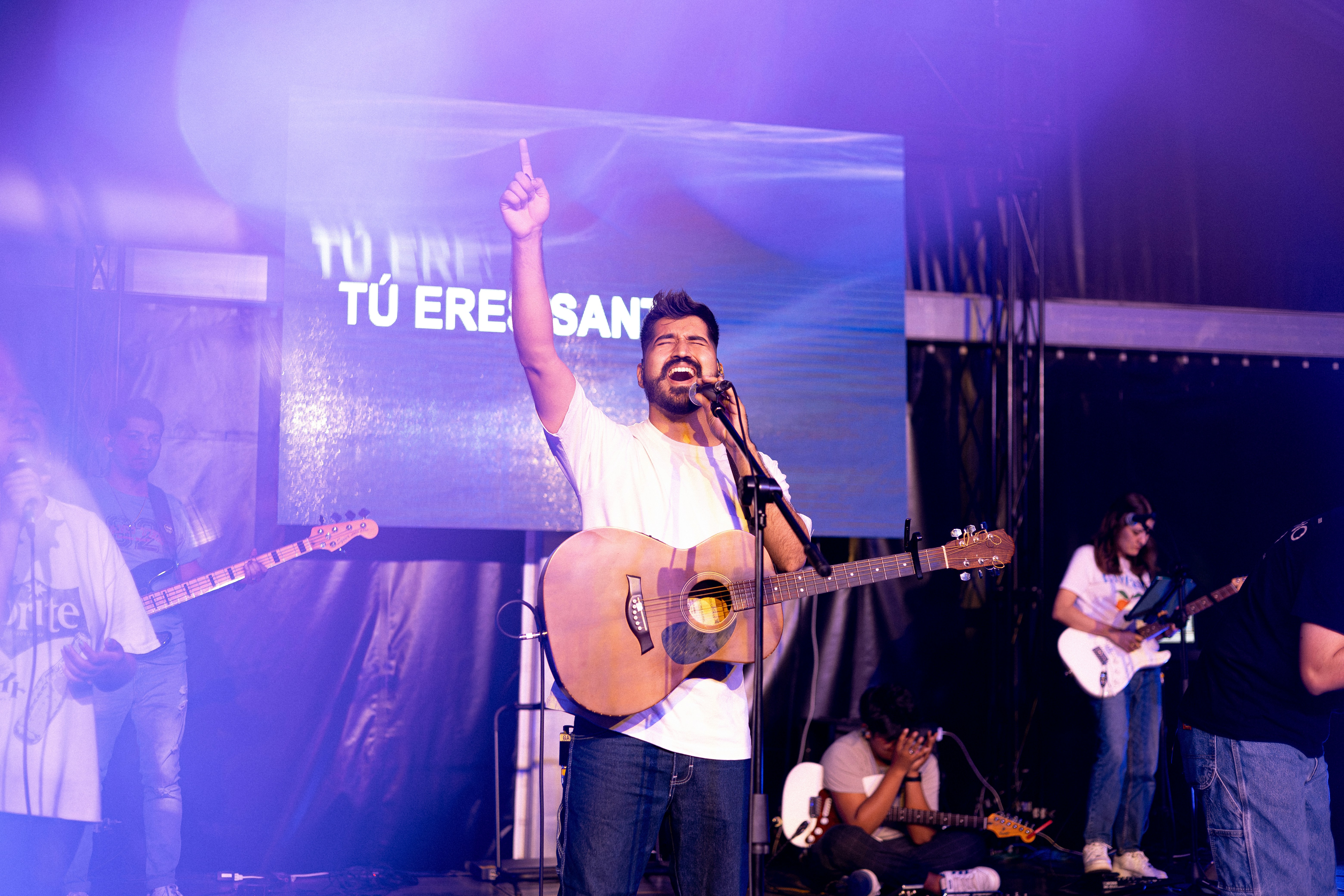a man singing into a microphone while holding a guitar