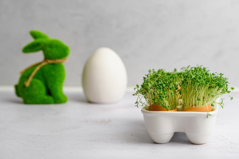 an egg shell shaped like a rabbit and a plant in a bowl