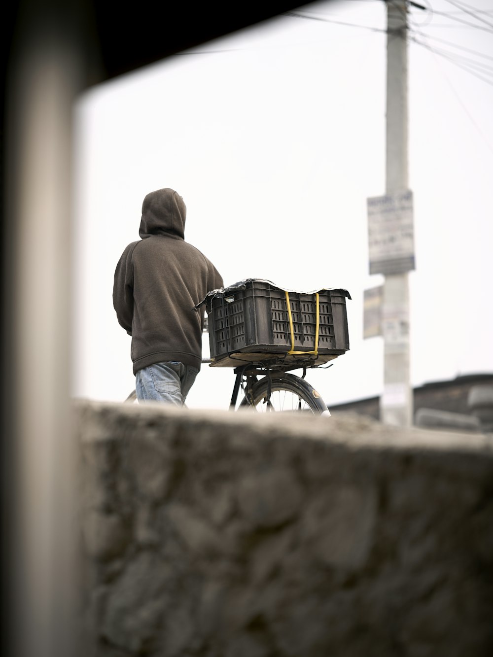 a man walking a bike with a basket on the back of it