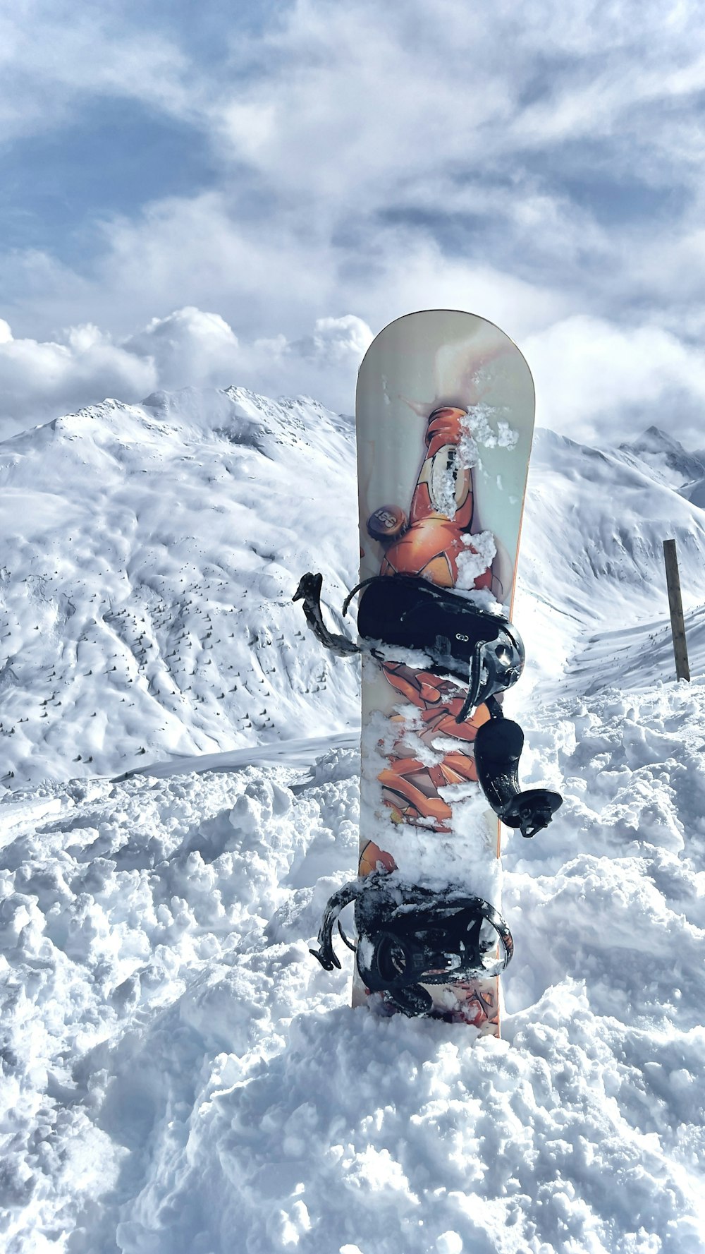 a snowboard sitting in the snow on top of a mountain