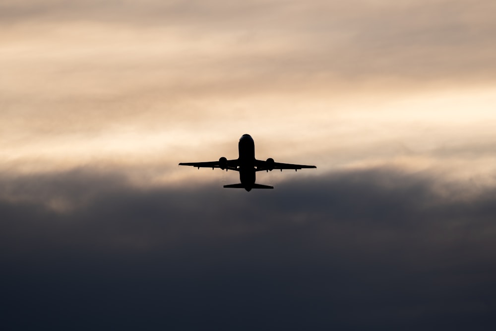 un avión volando en el cielo con un fondo nublado