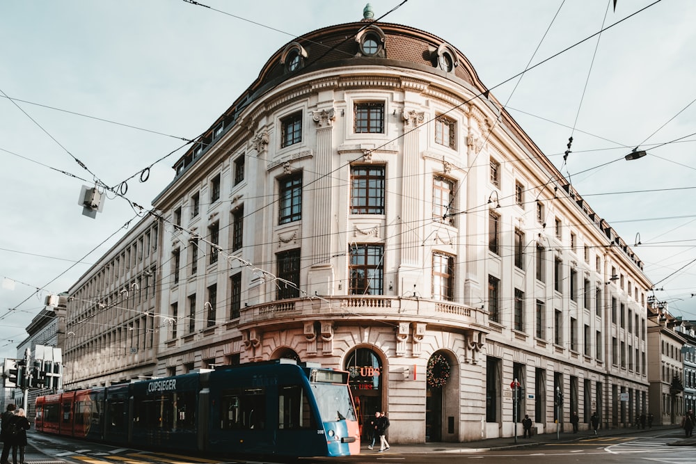 a blue and white train on a city street