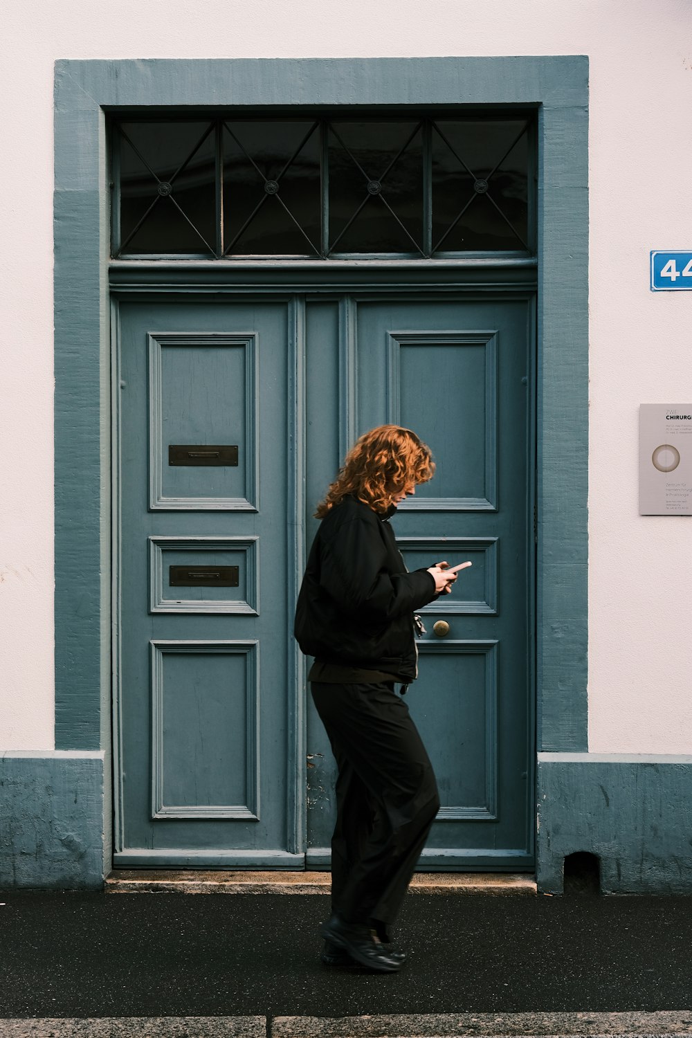青いドアの前に立つ女性
