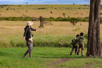 a group of people standing on top of a lush green field