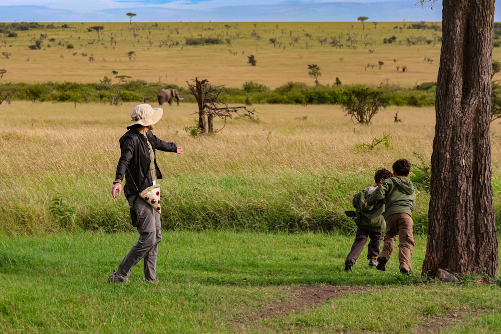 a group of people standing on top of a lush green field