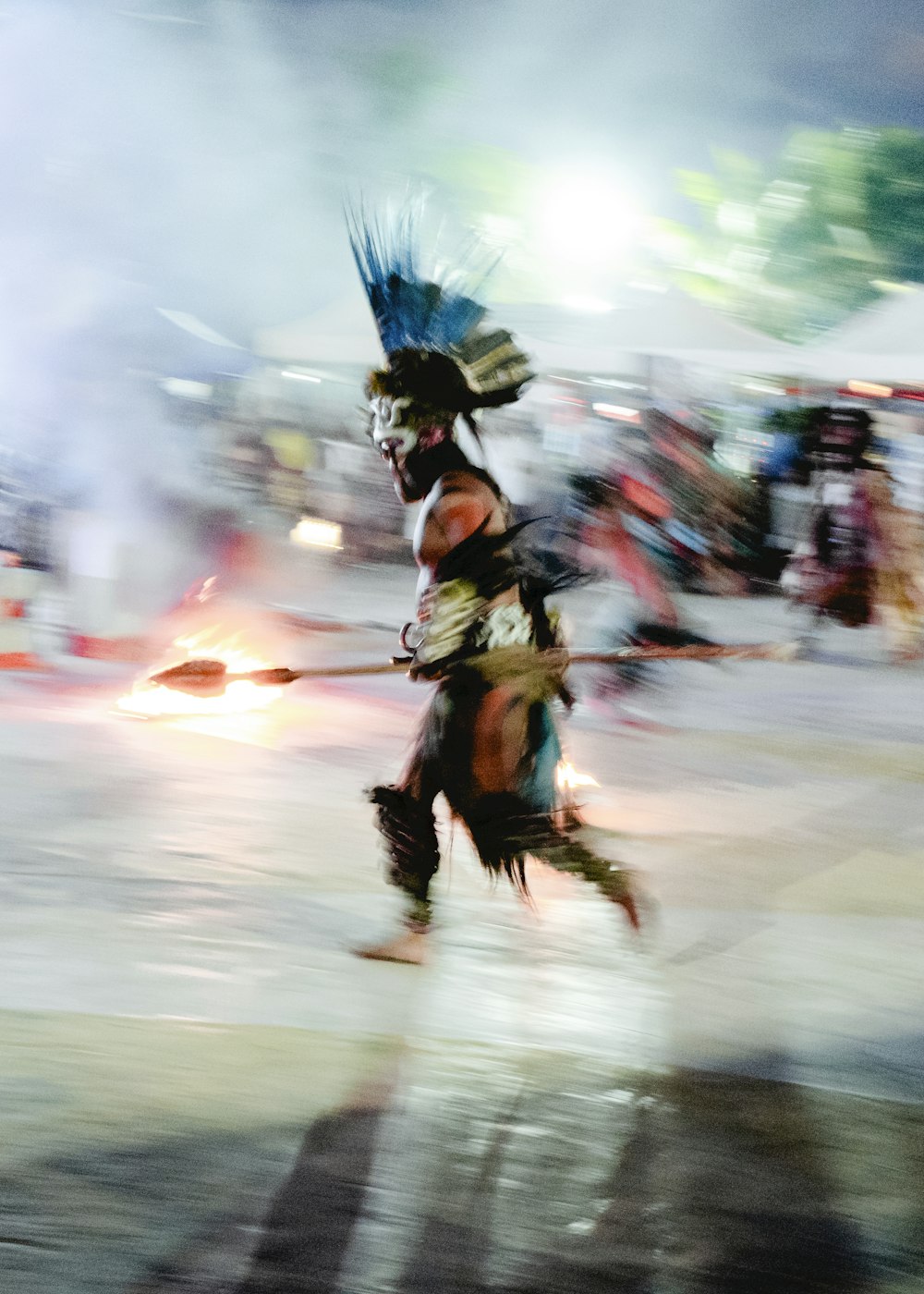 a man dressed in native american clothing running across a street