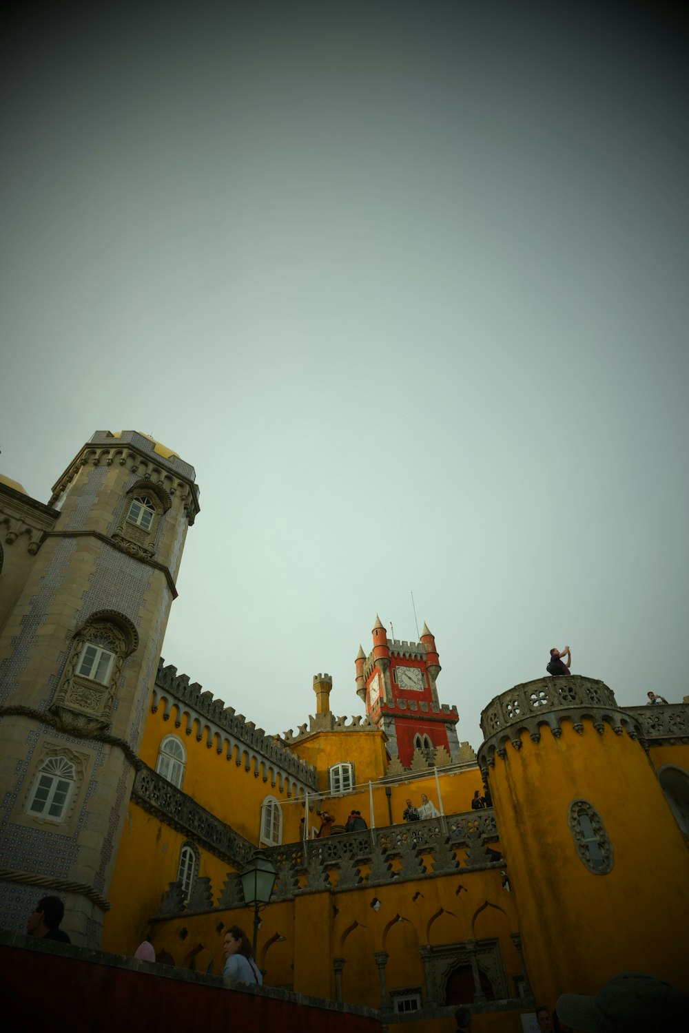 um grande castelo amarelo com uma torre do relógio