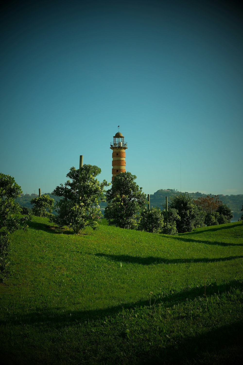 a light house in the middle of a green field