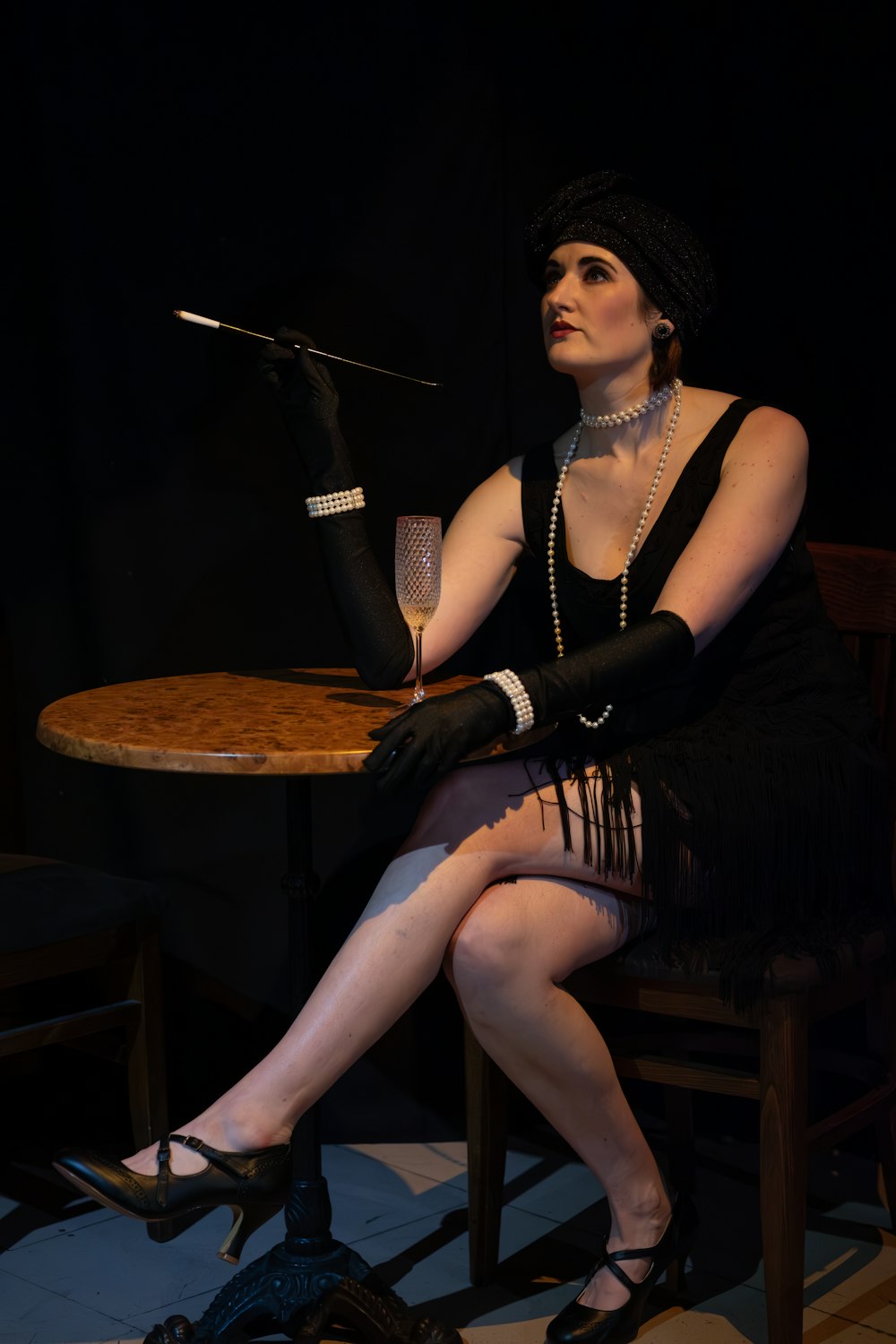 a woman sitting at a table with a wine glass