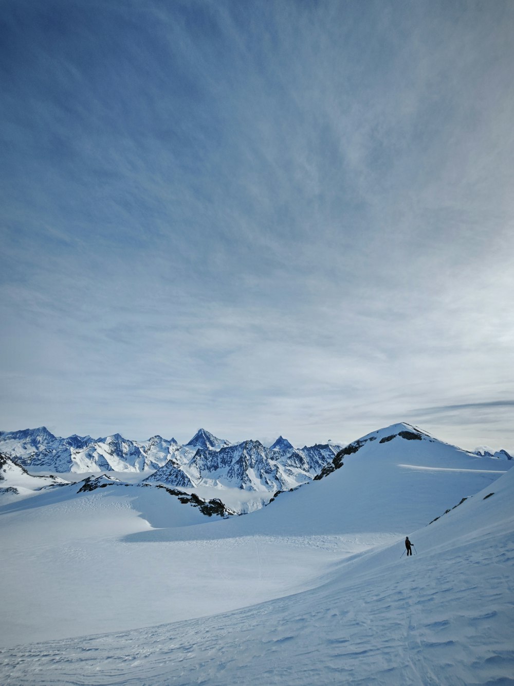 a person on skis in the snow with mountains in the background