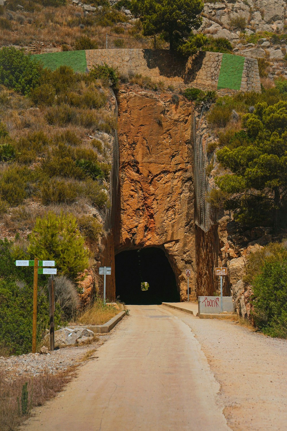 a road going into a tunnel on a hill