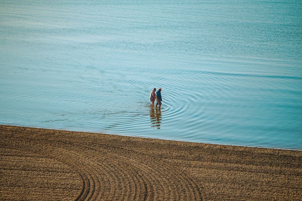 two people standing in a body of water