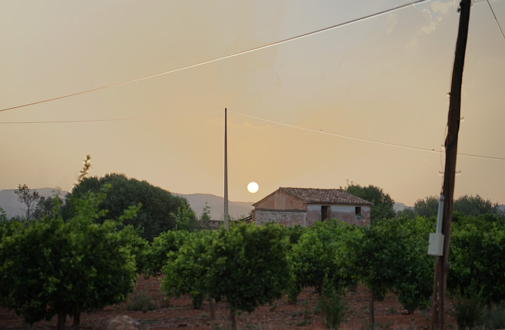 the sun is setting over a small building