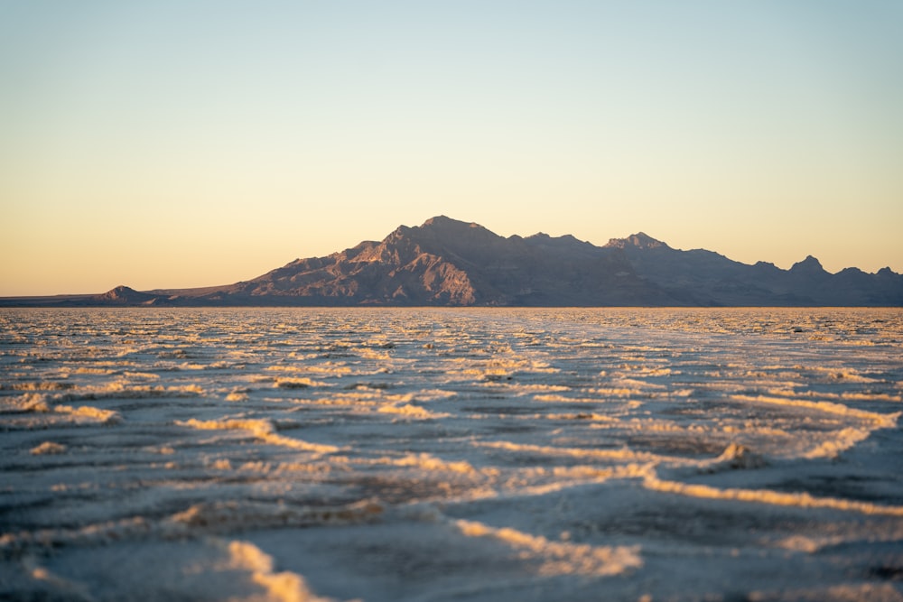 a large body of water with a mountain in the background