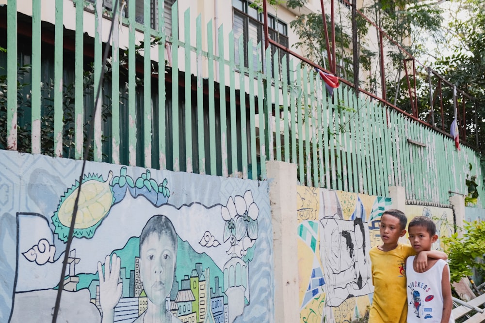 a couple of people standing next to a wall