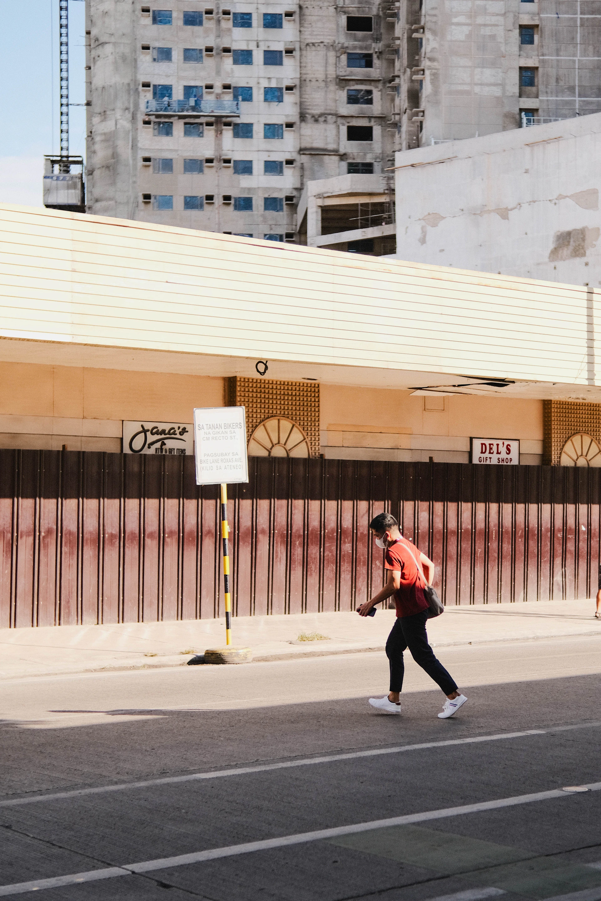 a man walking down the street in a red vest