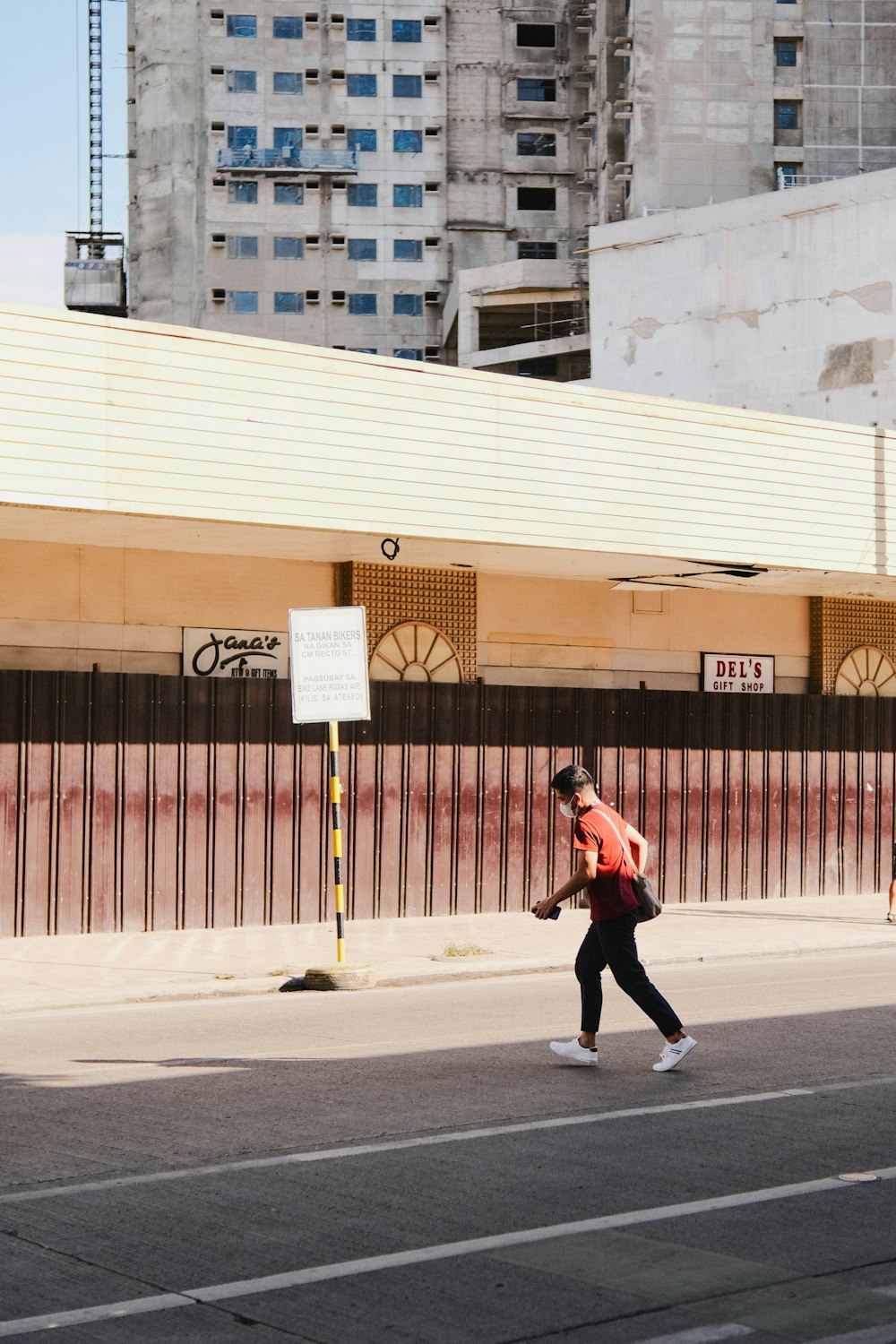 a man walking down the street in a red vest