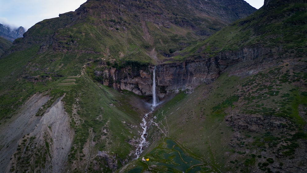 a waterfall in the middle of a mountain range
