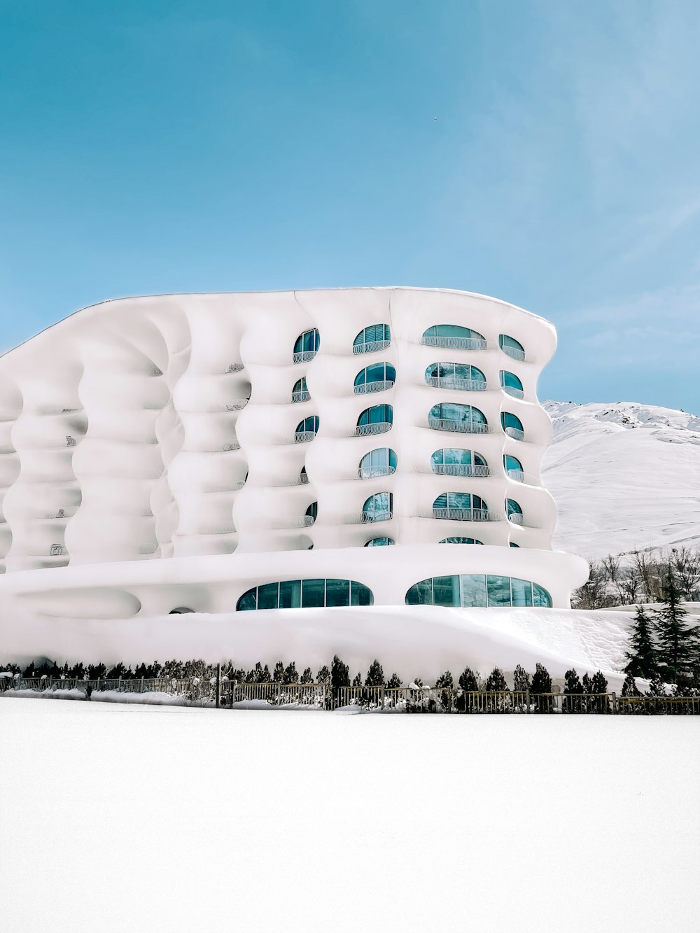 a large white building sitting on top of a snow covered field