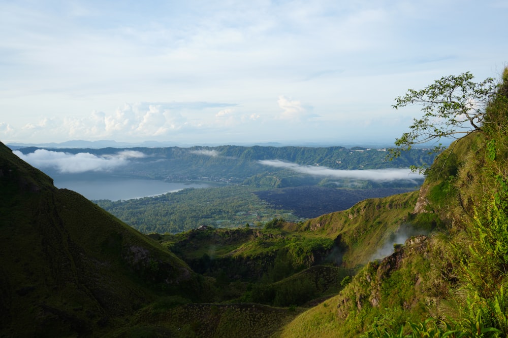 a view of a valley with a lake in the distance