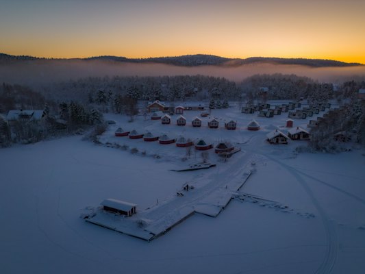 A village by a frozen lake, seen from above at dusk — Inari, Finland
