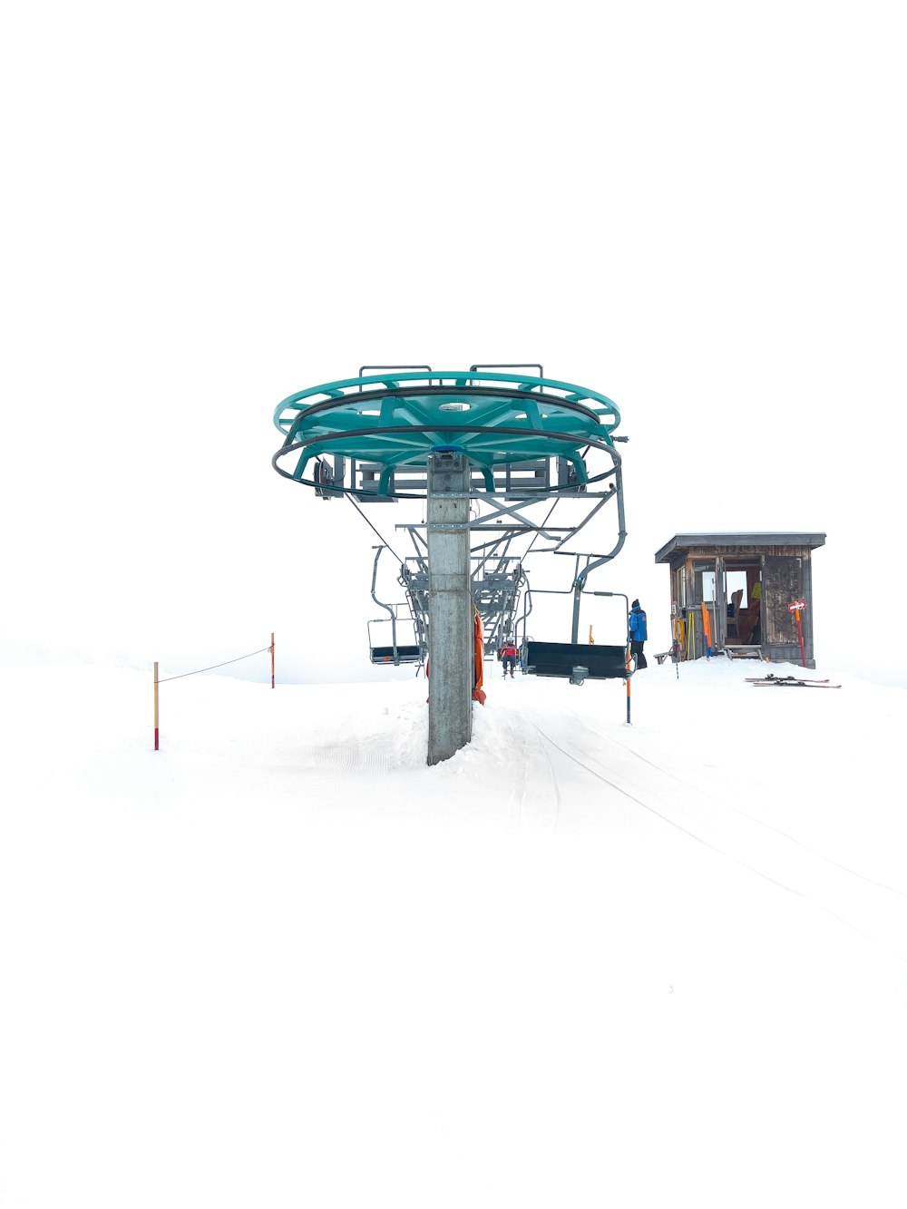 um teleférico sentado no topo de uma encosta coberta de neve